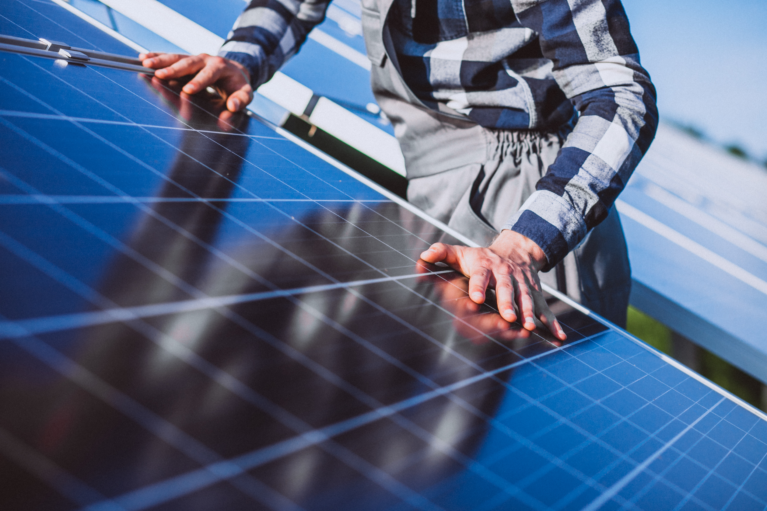 Are Solar Panels Worth Investing In? 7 man-worker-firld-by-solar-panels (1).jpg