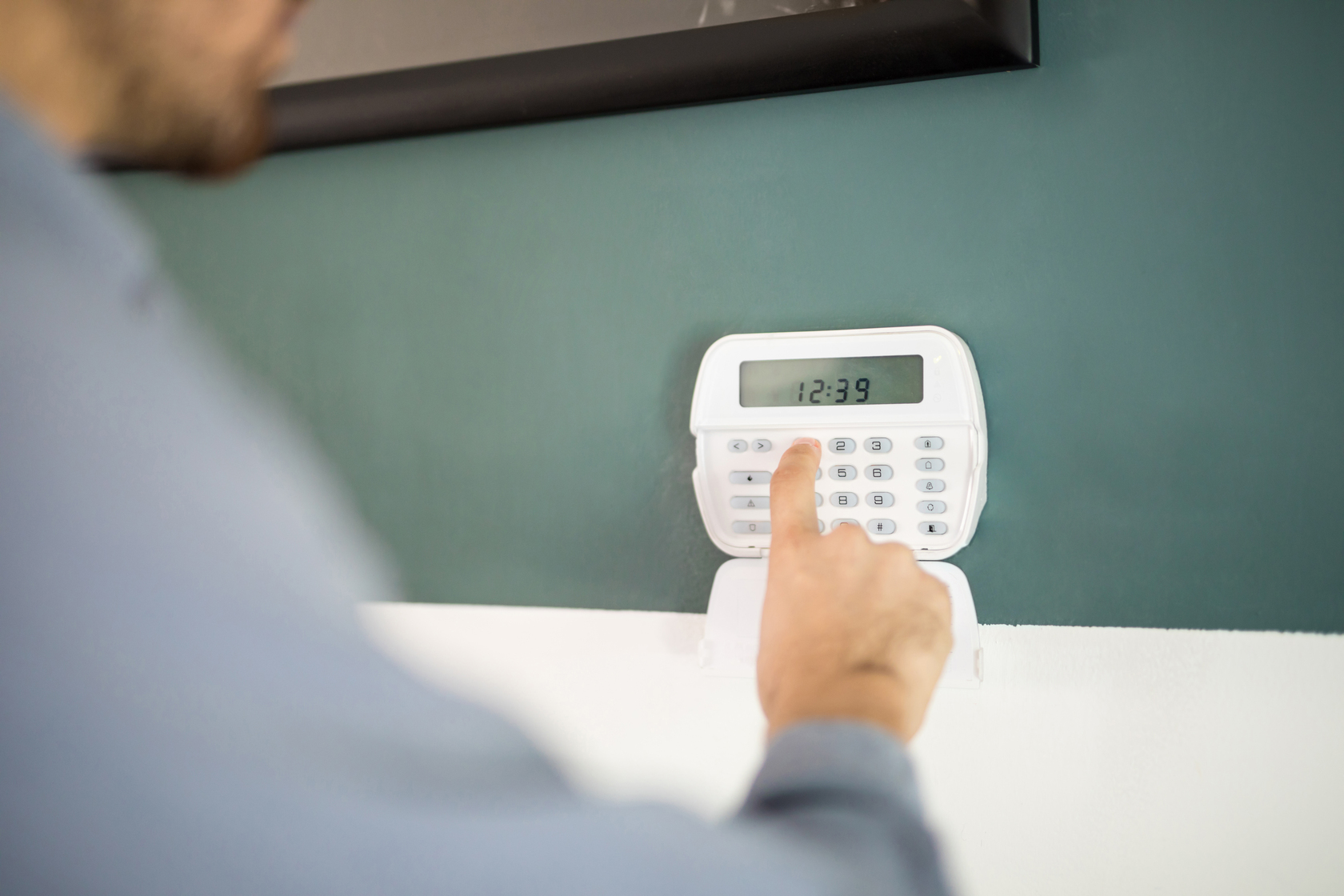 Alarm Systems Comparison 7 closeup-hand-man-using-keypad-arm-his-home-alarm-system.jpg